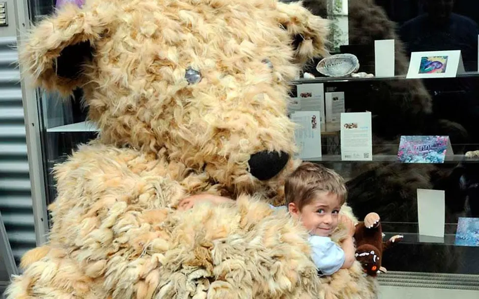 IKEA-Bär Darren umarmt einen Jungen IKEA-Bär Darren umarmt einen Jungen