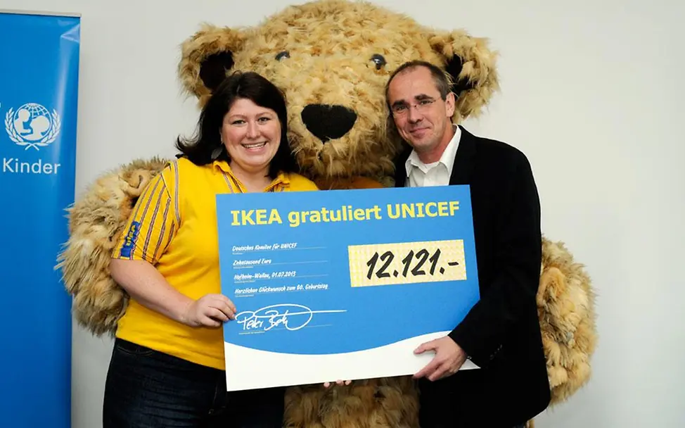 IKEA-Bär Darren mit dem Spendenscheck für UNICEF-Geschäftsführer Schneider IKEA-Bär Darren mit dem Spendenscheck für UNICEF-Geschäftsführer Schneider
