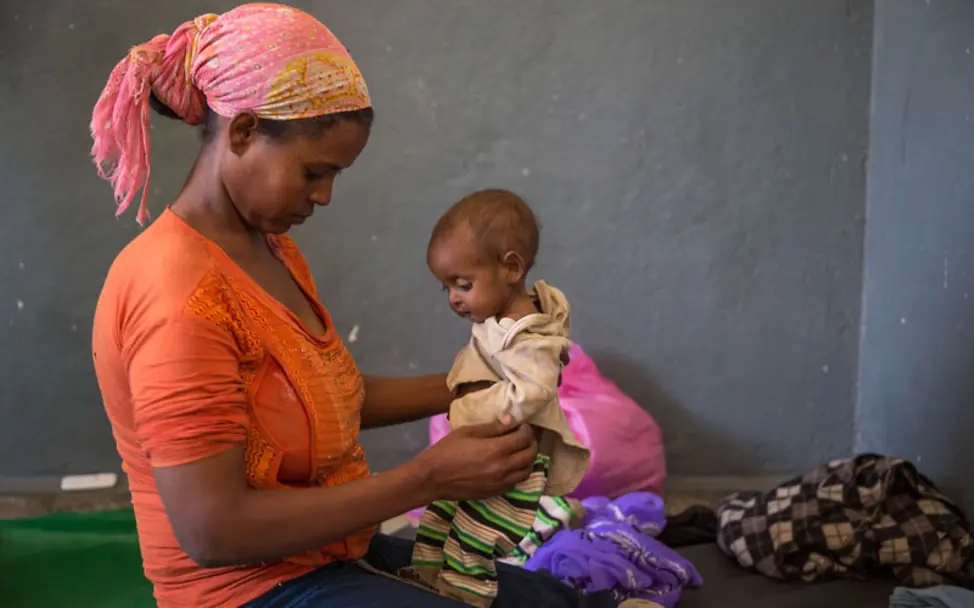 El Niño Äthiopien: Mütter erhalten therapeutische Nahrung für ihre Kinder | © UNICEF/Ayene El Niño Äthiopien: Eine Mutter hält ihr mangelernährtes Kind.