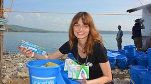 UNICEF-Botschafterin Eva Padberg hält Nothilfeartikel in Tacloban.