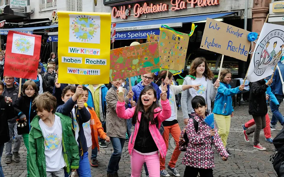 Kinder demonstrieren mit bunten, selbstgemachten Schildern für ihre Rechte