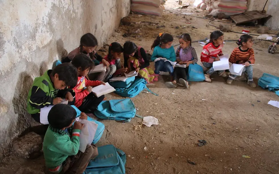 Lernen unter erschwerten Umständen. | © UNICEF/anonymous Kinder sitzen auf dem Boden im Kreis zusammen und lernen gemeinsam.