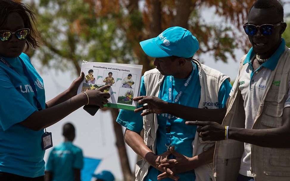 Südsudan. UNICEF-Helfer mit einem Buch