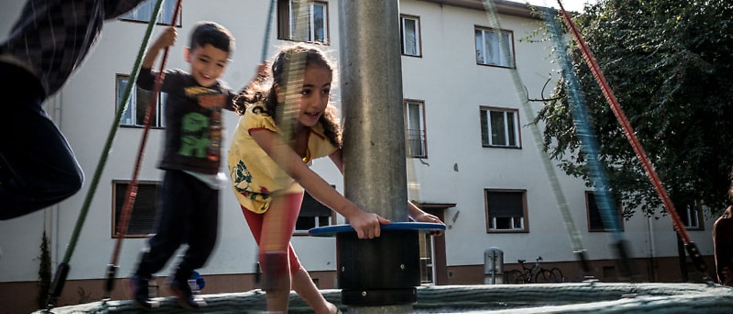 Die drei Kinder der Familie Raslan spielen draußen