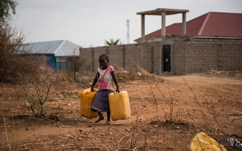 Südsudan: Ein Mädchen trägt Wasserkanister um sie mit Wasser zu füllen