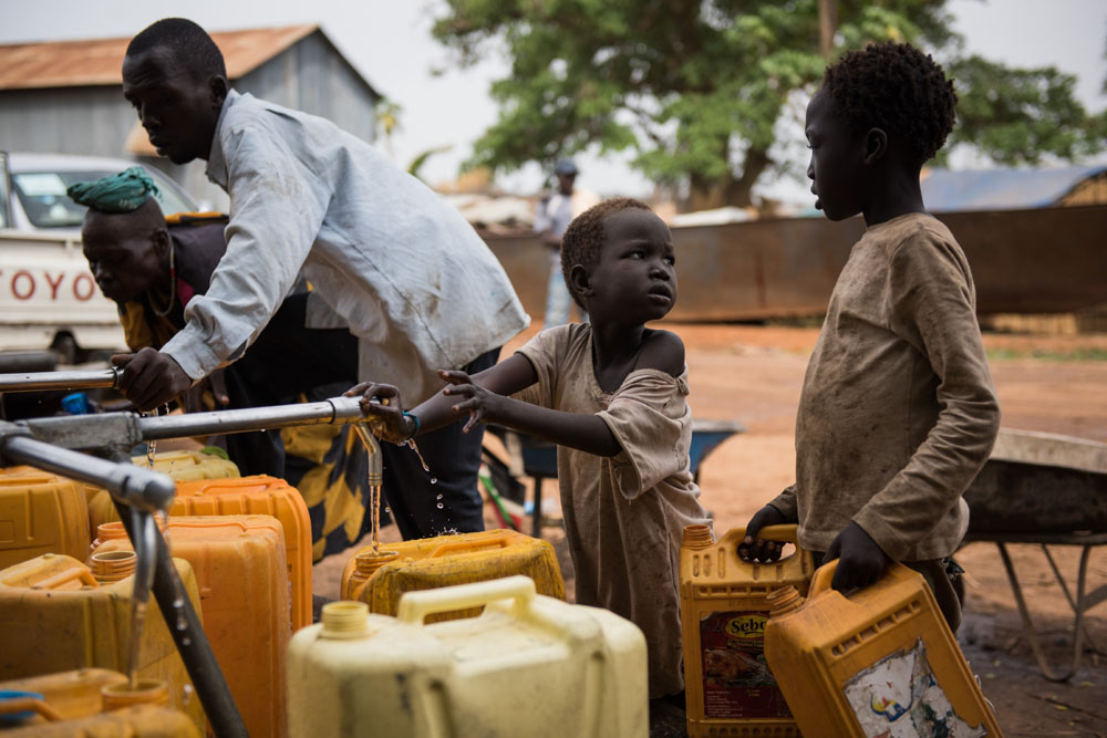 Südsudan: Ein Kind füllt sauberes Trinkwasser in einen Kanister ab