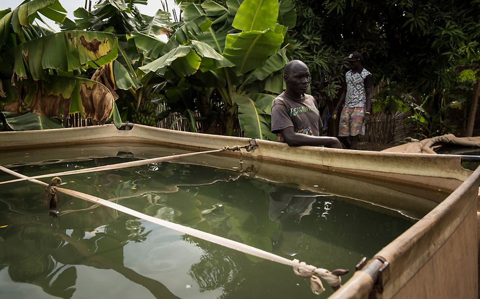 Südsudan: Louis steht neben einem Wasserspeicher mit Wasser aus dem weißen Nil