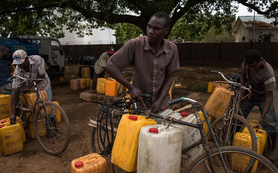 Südsudan: Ein Wasserverkäufer bindet Wasserkanister an sein Fahrrad