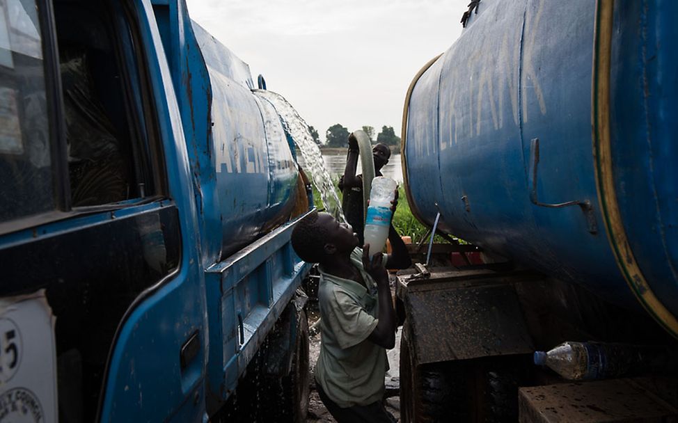 Südsudan: Francis steht zwischen zwei Wassertransportern