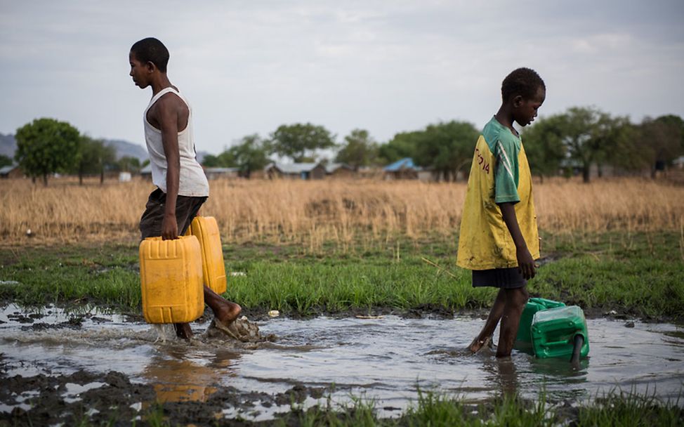 Südsudan: Zwei Jungs sammeln Wasser von einer kaputten Leitung