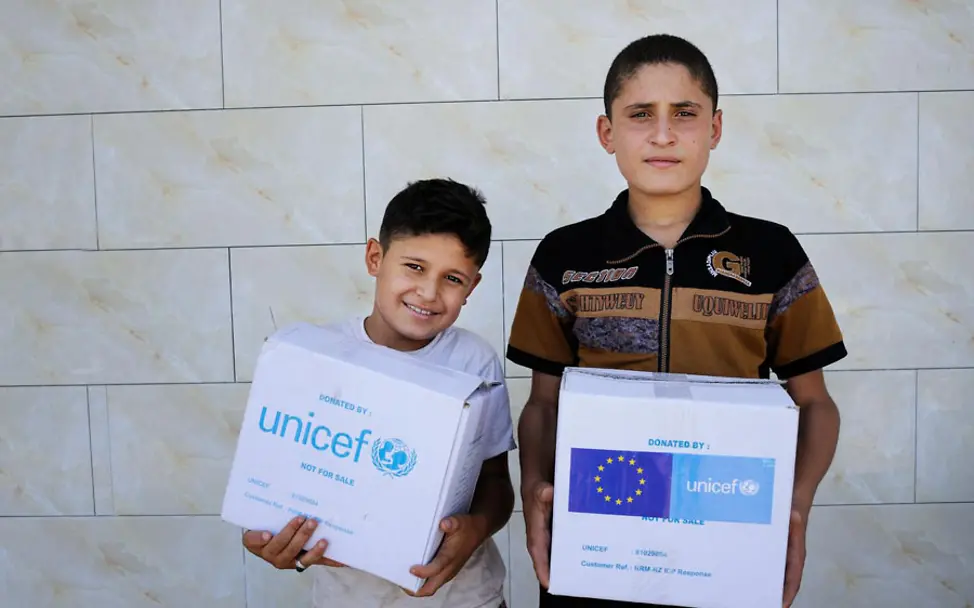 Abdul und Homaan freuen sich über ihre Hygien-Sets | © UNICEF/Mackenzie Syrien: Abdul und Homaan mit ihren Paketen voller Hygieneartikel