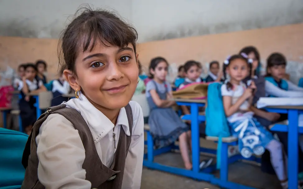 Ein Mädchen lächelt in einer von UNICEF wieder aufgebauten Schule im Irak. | © UNICEF/Anmar Ein Mädchen lächelt in einer von UNICEF wieder aufgebauten Schule im Irak.