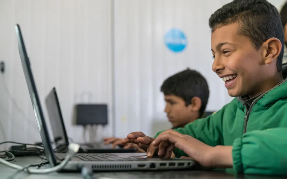 Bashar hat sichtlich Spaß beim spielen mit dem Laptop | © UNICEF/Herwig Makani: Bashar nutzt den laptop im Makani-Zentrum