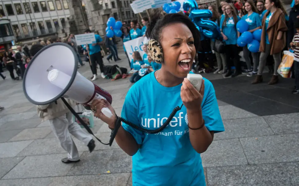 Jugendliche bei einer UNICEF-Kinderrechte-Demo in Köln | © UNICEF DT/Dirk Gebhardt Jugendliche Engagierte bei einer UNICEF-Kinderrechte-Demo in Köln: Sie ruft etwas in ein Megafon.