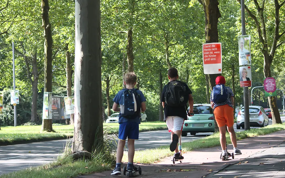 Zahlreiche Wahlplakate werben mit Wahlversprechen für Kinder | © UNICEF DT/Kristina Müller Bundestagswahl 2017: Kinder fahren mit Rollern an Wahlplakaten vorbei
