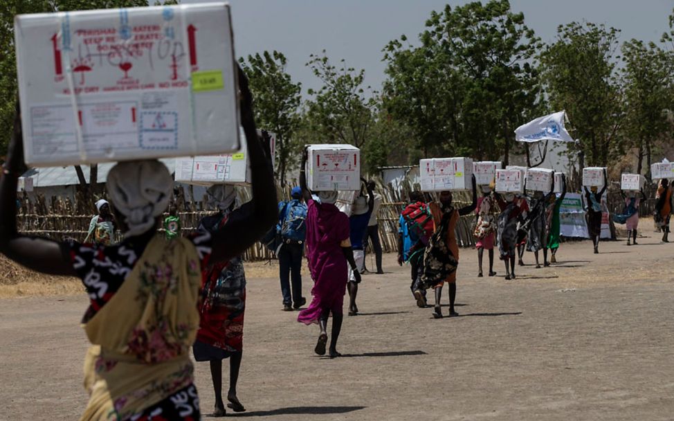 Südsudan: Frauen transportieren Kisten mit Impfstoffen durch die Straßen