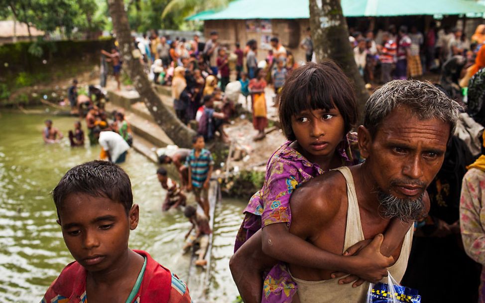 Ein Vater trägt seine Tochter nach der Überquerung der Grenze nach Bangladesch