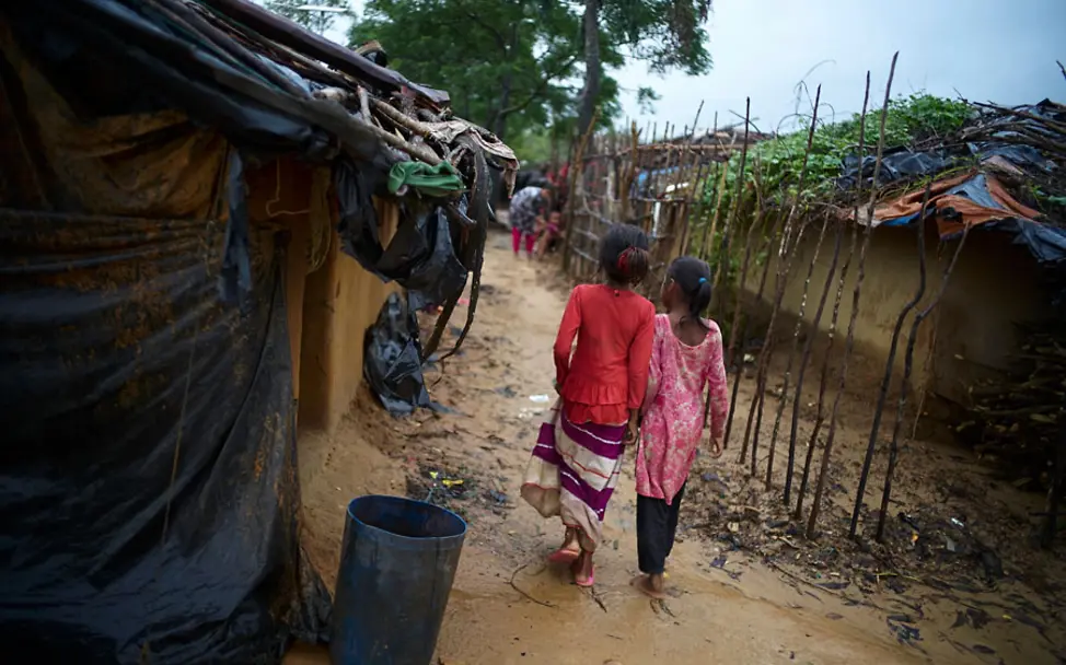 Yasmin und ihre Freundin laufen durch das matschige Flüchtlingslager. | © UNICEF/Noorani Rohingya-Bangladesch: Yasmin und ihre Freundin laufen durch das matschige Flüchtlingslager.