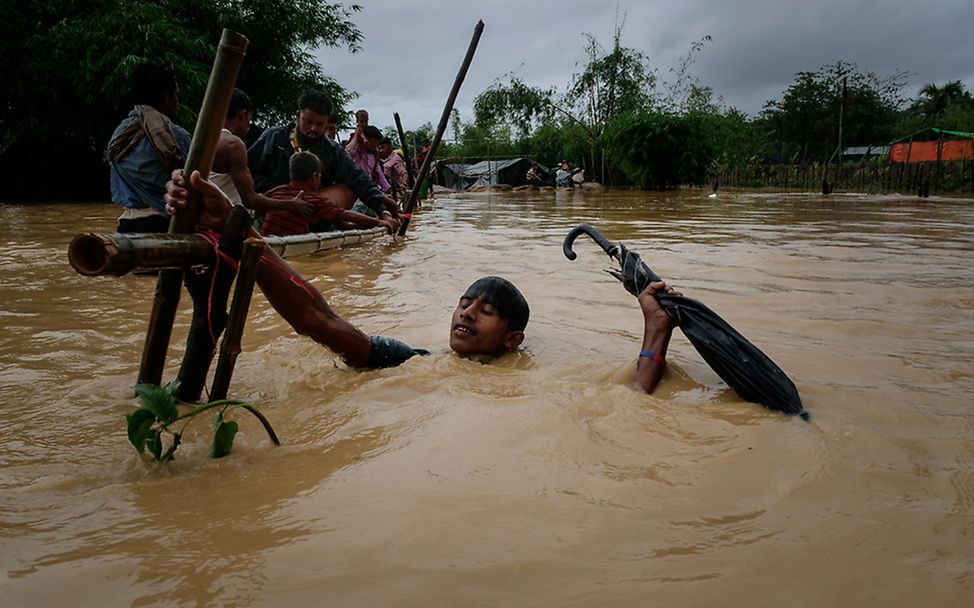 Rohingya: Ein Junge versucht sich aus den Fluten zu retten