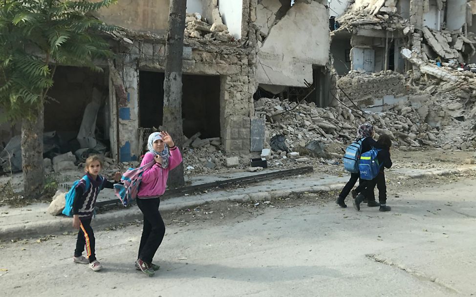 Syrien: Die Kinder sind mit UNICEF-Rucksäcken, zwischen den Ruinen von Aleppo, unterwegs