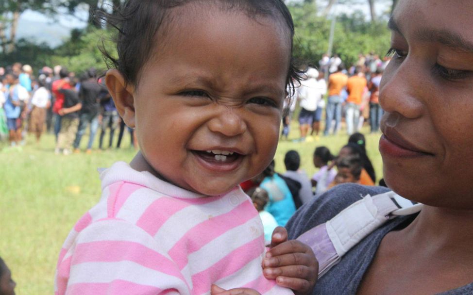 Timor-Leste: Ein lachendes Baby in den Händen ihrer Mutter