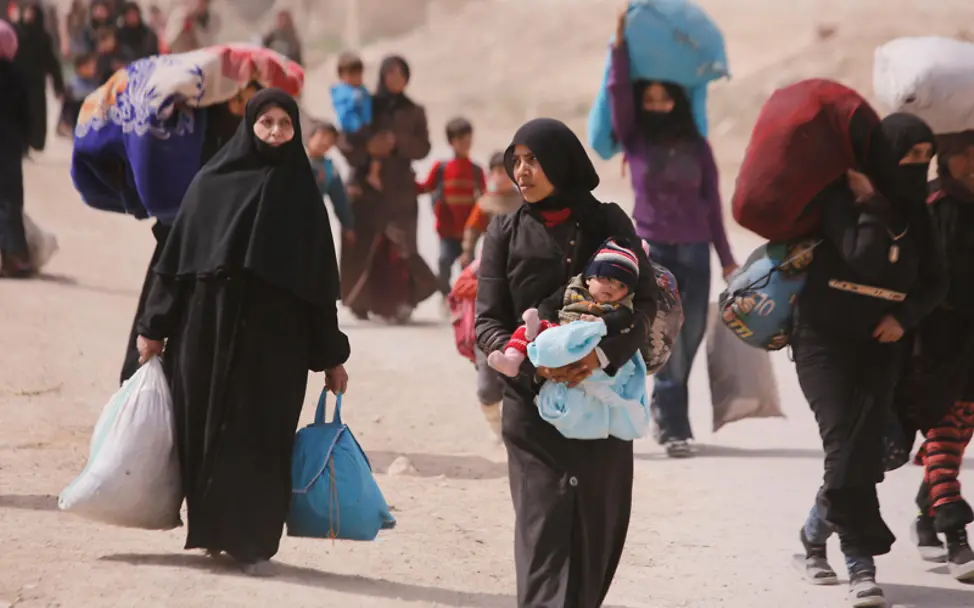 Tausenden fliehen komplett beladen aus Ost-Gouta | © UNICEF/UN0185408/Sanadiki Syrien: Auf der Flucht trägt eine Mutter ihr Kind auf dem Arm