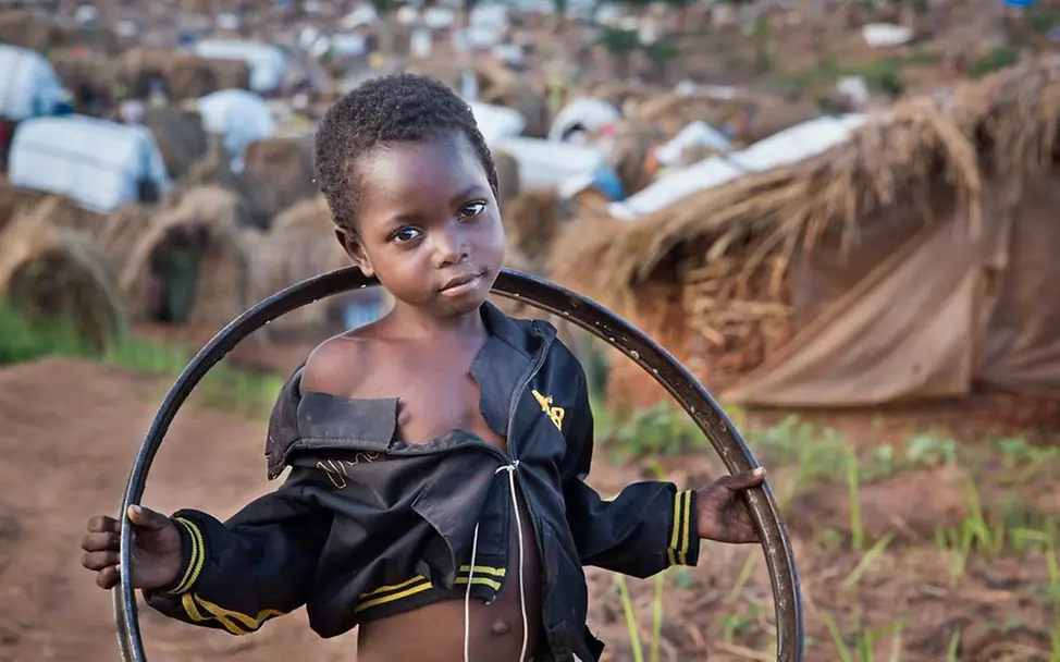 Ein binnenvertriebenes Mädchen spielt am Rande eines Lagers mit einer Fahradfelge. © UNICEF/Gabriel Vockel Ein binnenvertriebenes Mädchen spielt am Rande eines Lagers mit einer Fahradfelge.