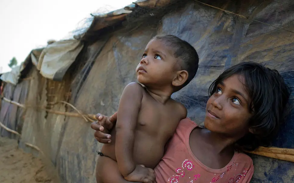 Bangen vor dem Regen: Geflüchtete Rohingya in Bangladesch| © UNICEF/Sokol Zwei Rohingya-Kinder in Bangladesch sehen besorgt in Richtung Himmel.
