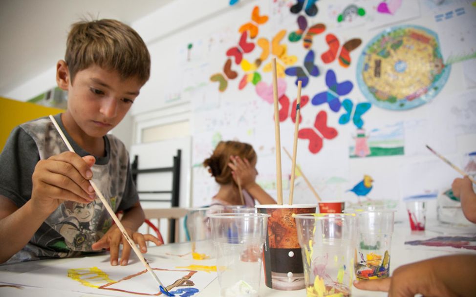 Im UNICEF Zentrum für Geflüchtete in Athen malt ein Kind.