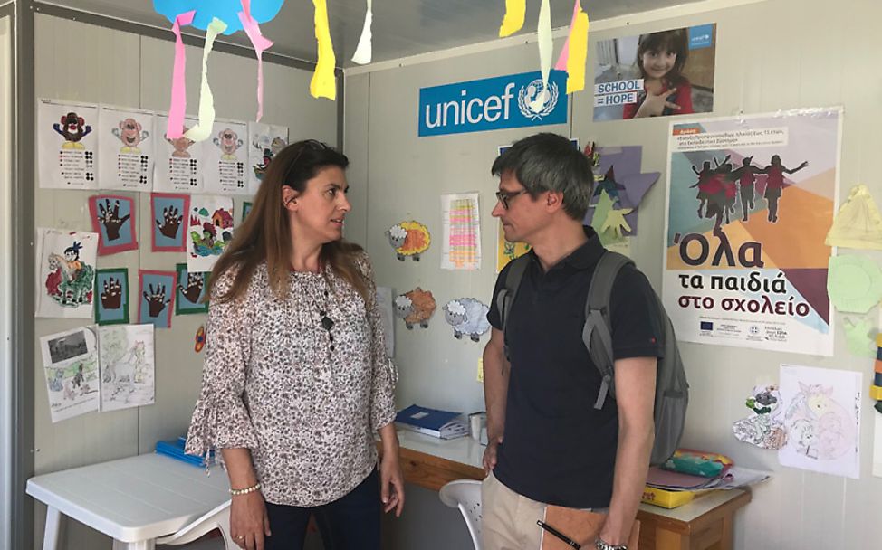 UNICEF-Mitarbeiter Sebastian Sedlmeyer spricht mit einer Helferin im Containerlager Kara Tepe..