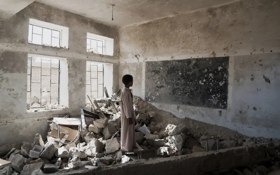 Auch die Schulen wurden nicht von der Zerstörung verschont | © UNICEF/Clarke for UNOCHA Jemen: Ein Schüler steht in den Ruinen eines Klassenzimmers