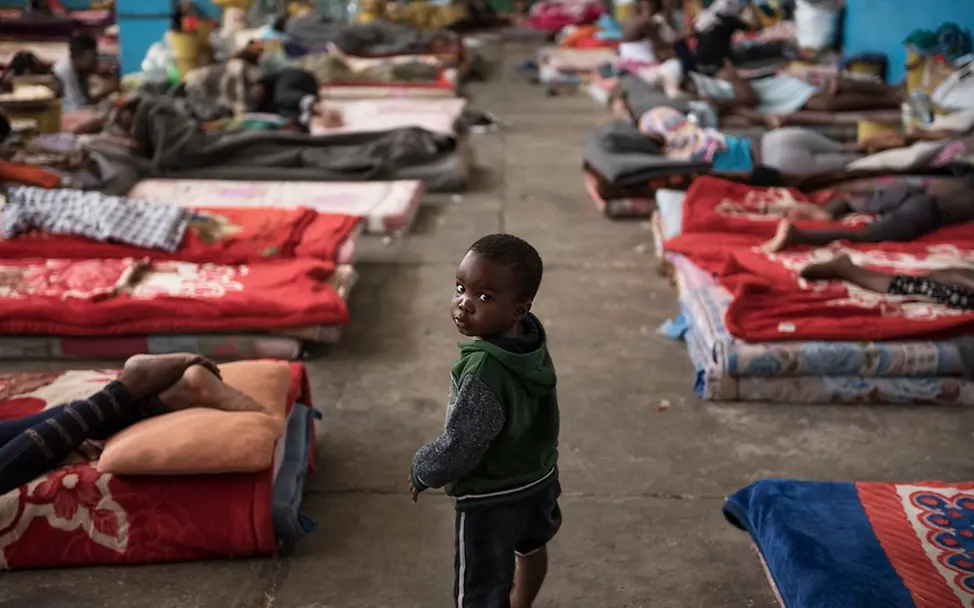 Ein wichtiger Schritt für Kinderrechte: Der Globale Migrationspakt | © UNICEF/Romenzi Libyen: Kind zwischen Matratzen im Flüchtlingslager