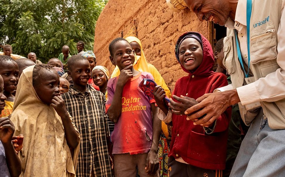 Daoussiya lacht mit UNICEF Kinderschutzexperte Moussa Yahaya.