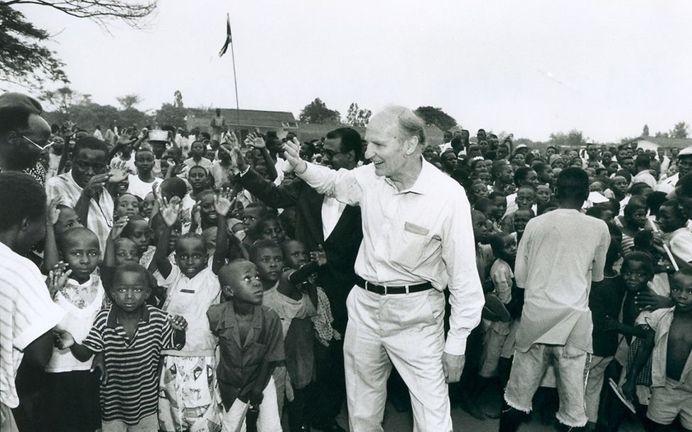 Reinhard Schlagintweit winkt Kindern und Jugendlichen in einem Projekt in Burundi.