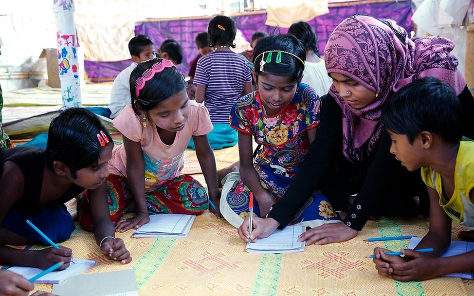 Eine Lehrerin unterrichtet Rohingya Flüchtlingskinder