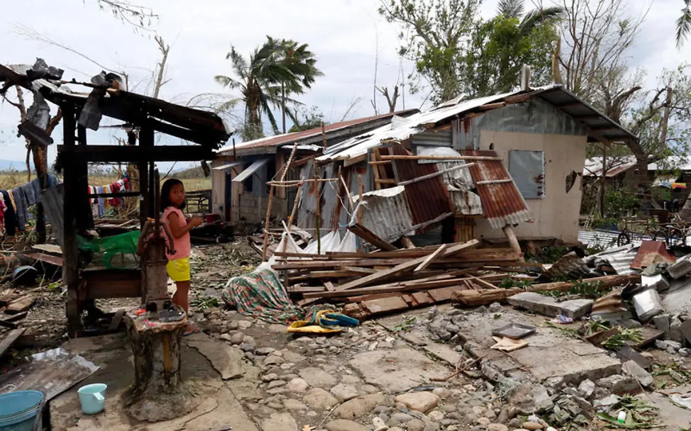 Nach dem Taifun auf den Philippinen steht ein Mädchen neben einem zerstörten Haus | © UNICEF/Maitem Philippinen Taifun Mangkhut: Ein Mädchen steht neben einem zerstörten Haus