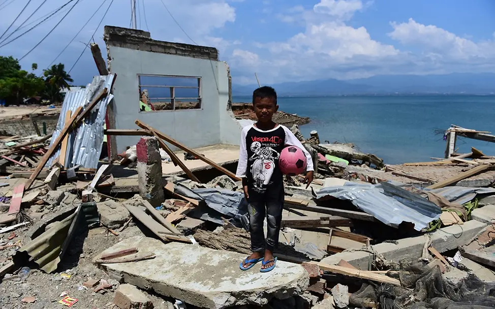 In Krisensituationen sind Kinder besonders gefährdet und brauchen speziellen Schutz. | © UNICEF/Wilander Ein Junge steht vor einem zerstörten Haus