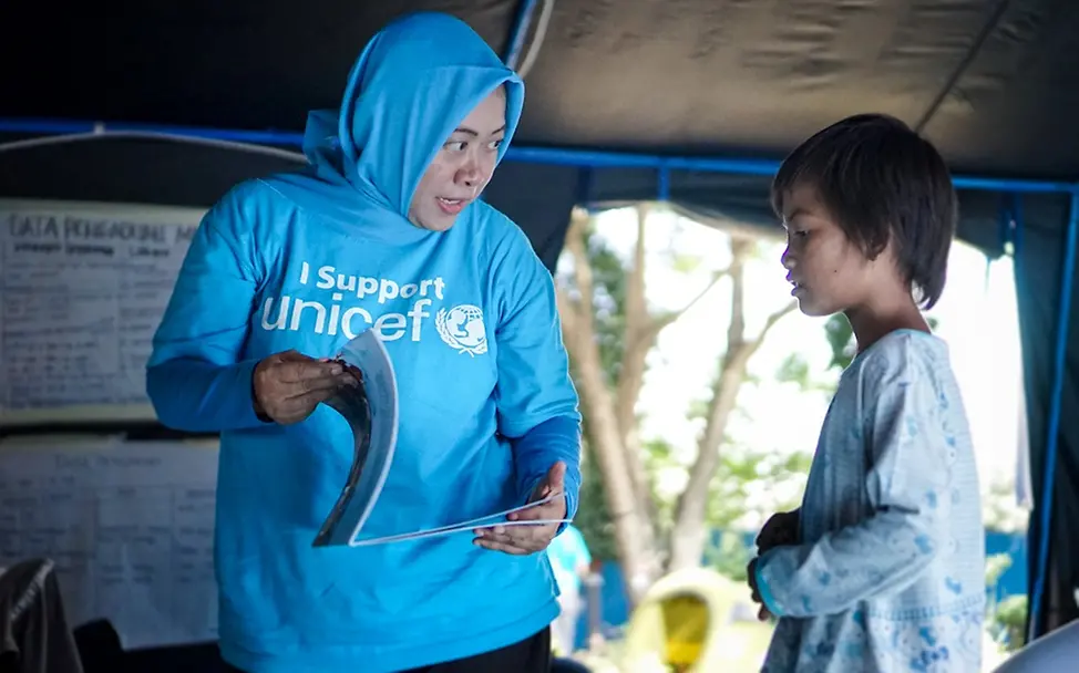 Naning erzählte Diah eine Geschichte darüber, wie stark ein Elefant ist. Es inspirierte Diah, auch stark zu sein. | © UNICEF/Veska Ein Junge erhält psychosoziale Unterstützung einer UNICEF-Kinderschutbeauftragten.