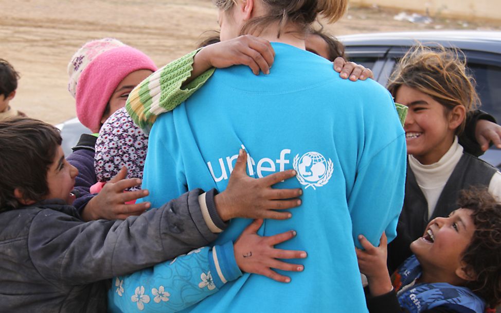 Jordanien: Kinder umarmen eine UNICEF-Helferin