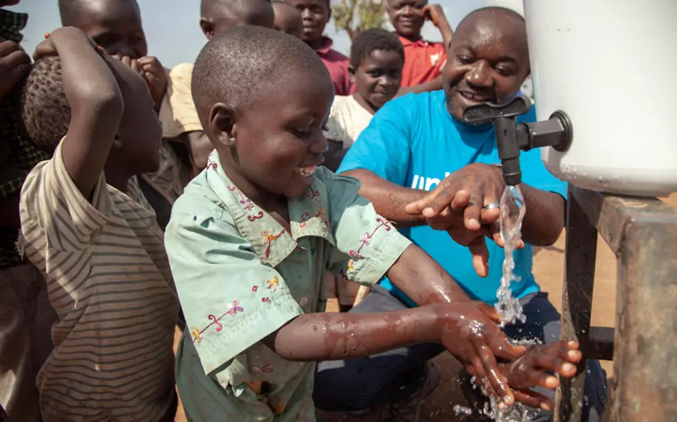 Ein UNICEF-Mitarbeiter bringt Kindern im Kongo Händewaschen bei | © UNICEF/Naftalin Kongo: UNICEF-Mitarbeiter zeigt Kindern, wie sie sich die Hände waschen