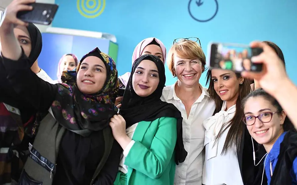 Selfie mit Elke Büdenbender. | © dpa 30 Jahre Kinderrechte: Junge Mädchen im Libanon machen Selfies mit Elke Büdenbender.