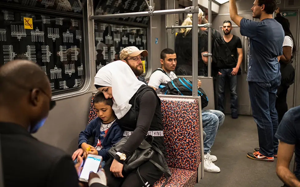 Deutsch sein, oder nicht Deutsch sein. | © UNICEF/Gilbertson VII Photo Berlin: Amira und ihr fünfjähriger Sohn sitzen in der U-Bahn.