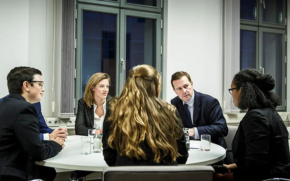 Sandra nimmt sich der Stimme der Jugend an. | © Bundesregierung/Denzel Sandra und zwei Mitgliedern des UNICEF-JuniorBeirats am Besprechungstisch mit Steffen Seibert und einer Kollegin.