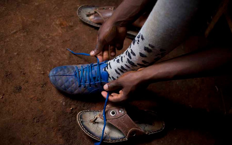 Burundi: Der 17-Jährige Jean-Pierre schnürt seine Fußballschuhe.