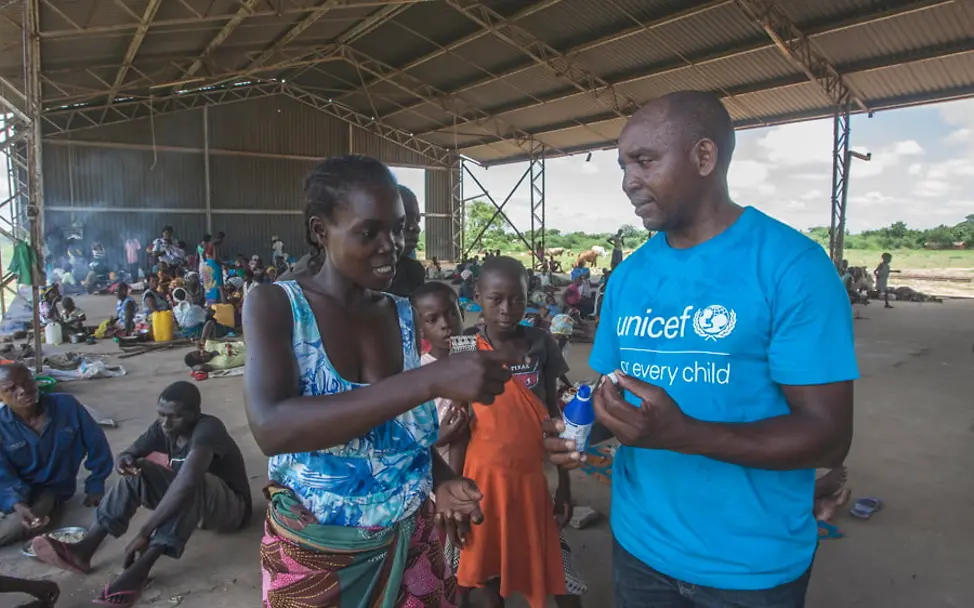UNICEF Mitarbeiter Alan Kumwenda hilft Annie in der Notunterkunft | © UNICEF Malawi/Amos Gumulira Wirbelsturm Idai: UNICEF Mitarbeiter Alan Kumwenda hilft Annie in der Notunterkunft