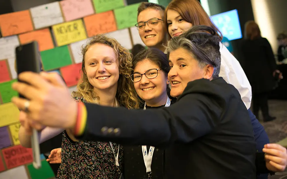 Ein letztes Selfie vor den Wunschplakaten. | © UNICEF Rumänien Bukarest: Vier Jugendliche machen vor der Plakatwand ein Selfie mit einer Regierungsvertreterin.