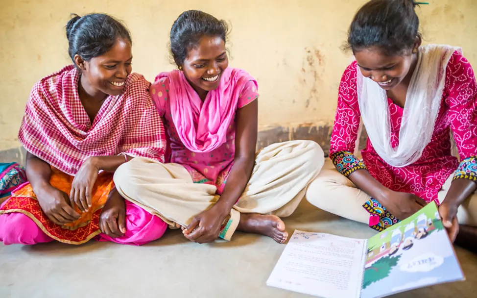 Die Mädchen gucken sich zusammen ein Buch an | © UNICEF/UN0215383/Vishwanathan Menstruation: Mädchen beim Studieren eines Buches
