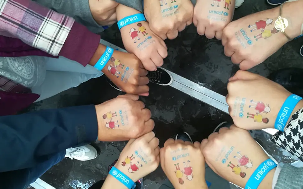 Zusammenhalt beim Weltkindertag-Fest in Köln | © UNICEF/Stefanie Hack Weltkindertag Köln: Kinder bilden mit ihren Fäusten einen Kreis.