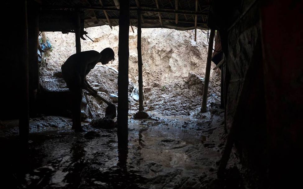 Monsun in Bangladesch 2019: Ein Mann schaufelt Schlamm aus seinem Haus