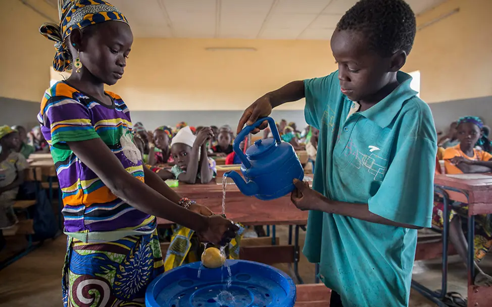 In der Schule wird auch Hygienewissen vermittelt. | © UNICEF/Dicko Mali: Fatoumata und ein Klassenkamerad zeigen ihren Mitschülern das richtige Händewaschen.